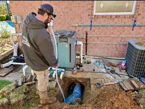 A technician at a pool heater install, with an open dig to a blue line.
